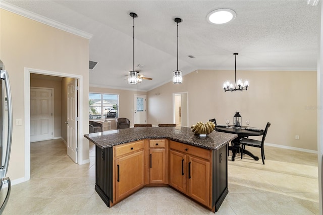 kitchen with pendant lighting, brown cabinets, vaulted ceiling, a kitchen island, and dark stone countertops