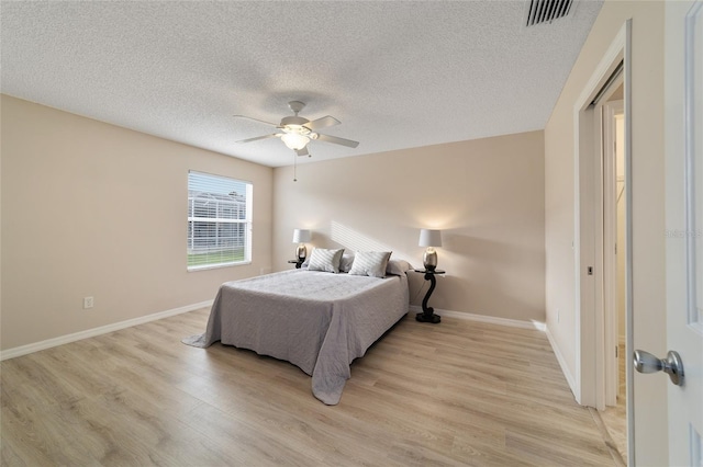 bedroom featuring visible vents, light wood-style flooring, and baseboards