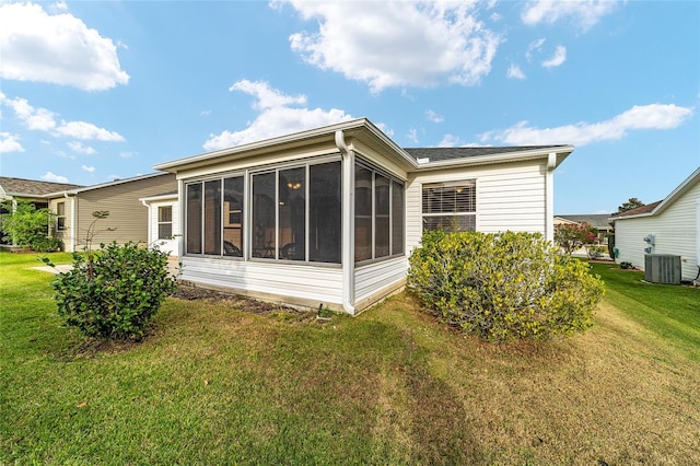 back of property with a lawn, cooling unit, and a sunroom