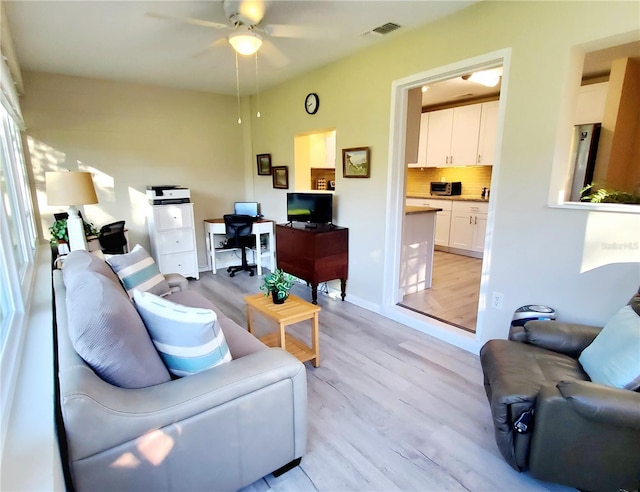 living room featuring ceiling fan and light hardwood / wood-style flooring