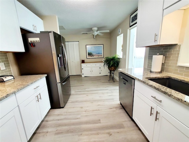 kitchen featuring light stone countertops, white cabinetry, and stainless steel appliances