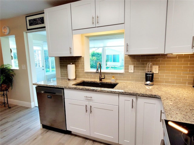 kitchen with a wealth of natural light, white cabinetry, sink, and stainless steel dishwasher