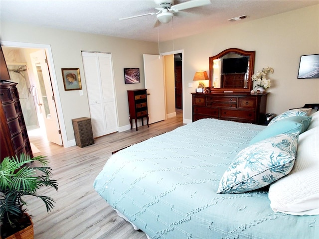 bedroom featuring ceiling fan, a closet, ensuite bathroom, and light hardwood / wood-style flooring