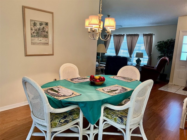 dining space with a notable chandelier, dark hardwood / wood-style floors, and a textured ceiling