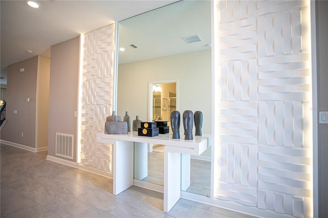 bar with light tile patterned floors and a textured ceiling