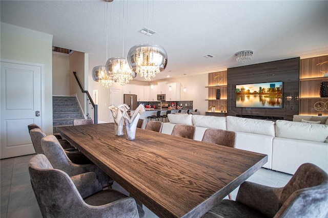 dining space featuring a chandelier, a textured ceiling, and light tile patterned flooring