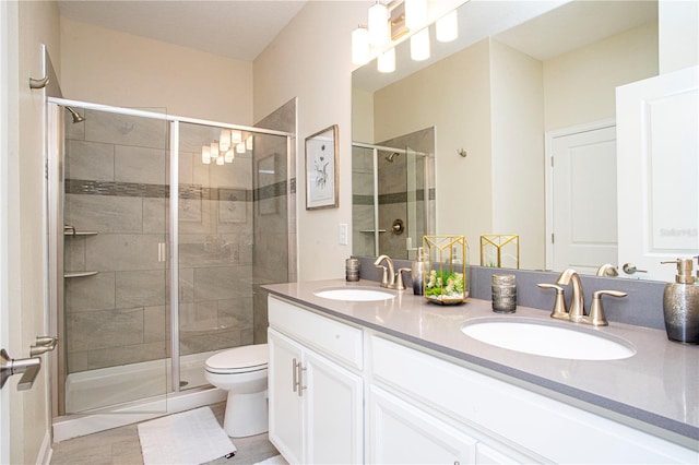 bathroom with tile patterned floors, vanity, toilet, and an enclosed shower