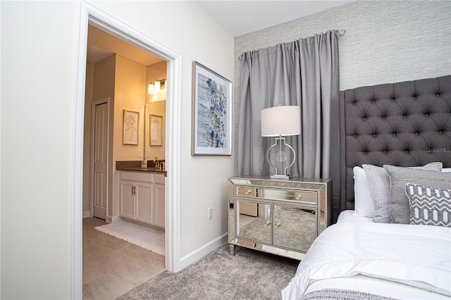 bedroom with ensuite bathroom and sink