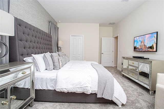 carpeted bedroom featuring a textured ceiling and a closet