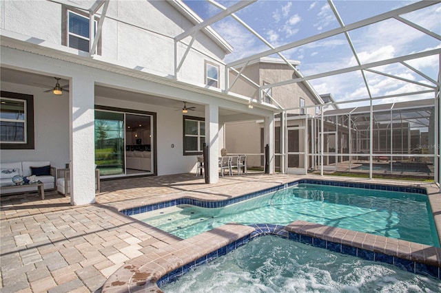 view of swimming pool featuring ceiling fan, a lanai, a patio, and an in ground hot tub