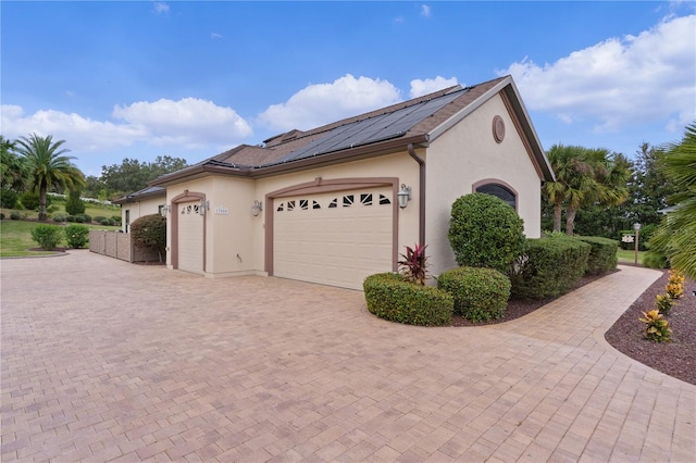 view of home's exterior with solar panels and a garage