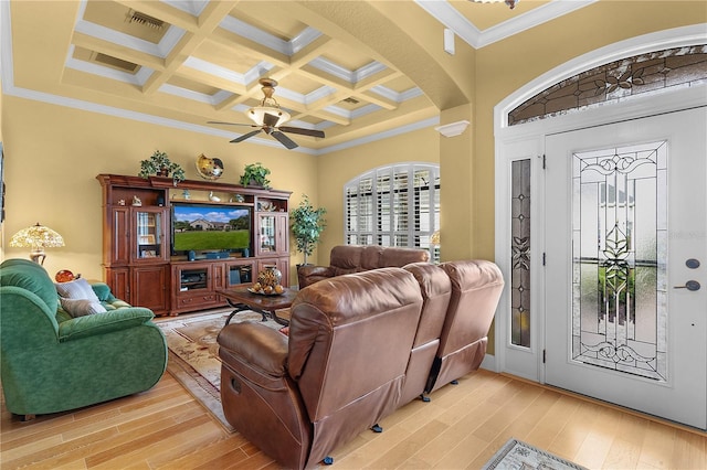 living room featuring coffered ceiling, light hardwood / wood-style flooring, ceiling fan, ornamental molding, and beamed ceiling