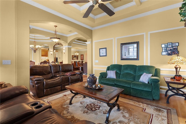 living room featuring ceiling fan with notable chandelier, decorative columns, light hardwood / wood-style flooring, and ornamental molding