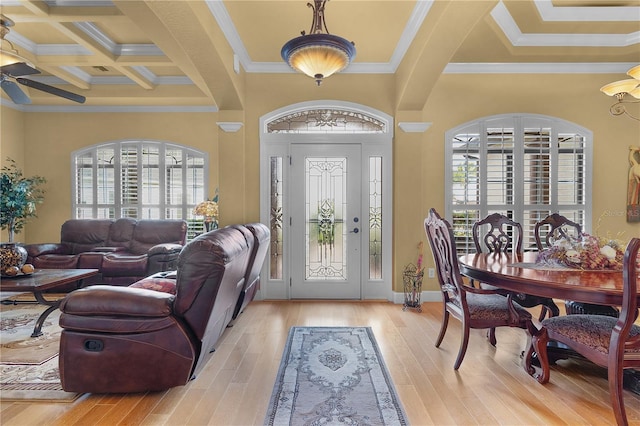 foyer entrance featuring light hardwood / wood-style flooring, a wealth of natural light, ornamental molding, and coffered ceiling