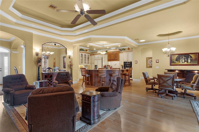 living room with a raised ceiling and crown molding