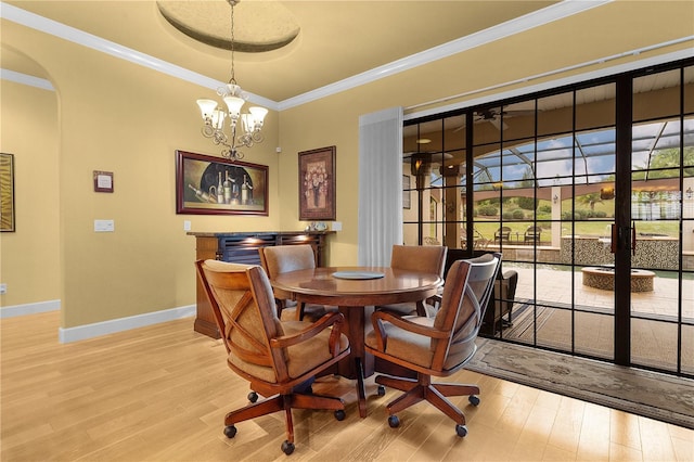 dining space featuring hardwood / wood-style flooring, crown molding, and a notable chandelier