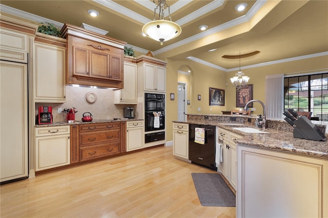 kitchen with black appliances, crown molding, hanging light fixtures, and cream cabinetry