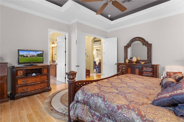 bedroom with ceiling fan, light wood-type flooring, ornamental molding, and connected bathroom