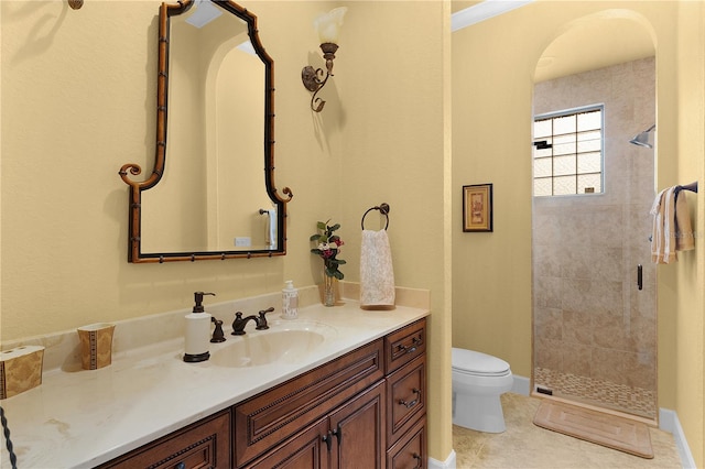 bathroom with tile patterned flooring, vanity, tiled shower, and toilet