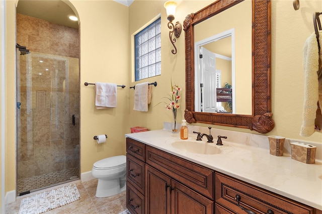 bathroom with tile patterned floors, vanity, toilet, and a shower with shower door