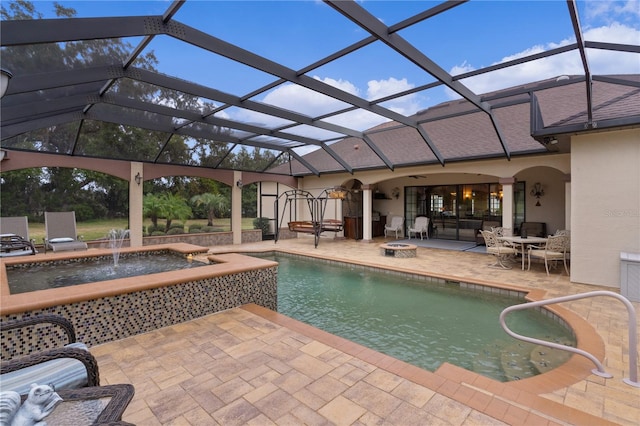 view of swimming pool with glass enclosure, pool water feature, and a patio