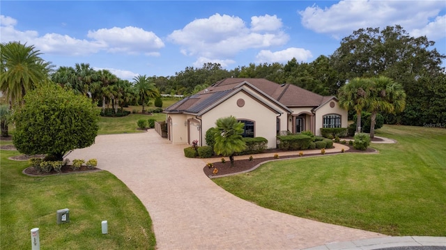 view of front of house with solar panels and a front lawn