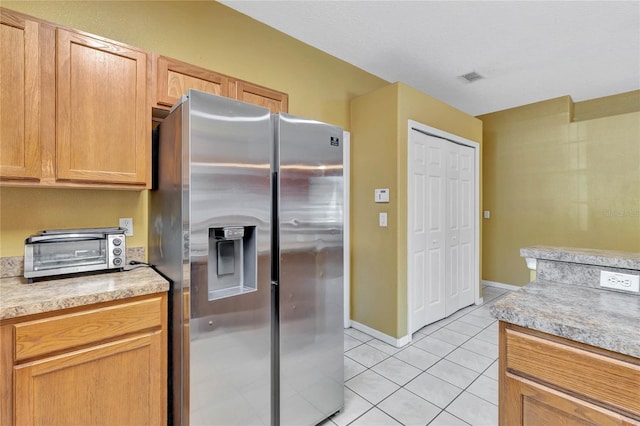 kitchen featuring light tile patterned flooring and stainless steel refrigerator with ice dispenser