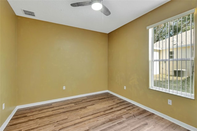 empty room with ceiling fan and light hardwood / wood-style floors