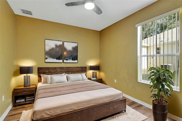 bedroom with multiple windows, ceiling fan, and light hardwood / wood-style flooring