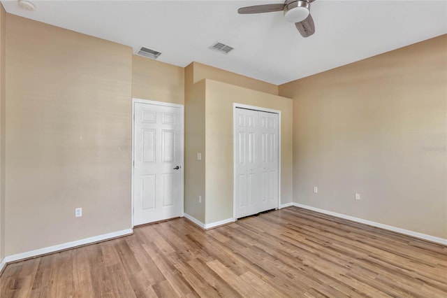 unfurnished bedroom featuring a closet, light hardwood / wood-style floors, and ceiling fan