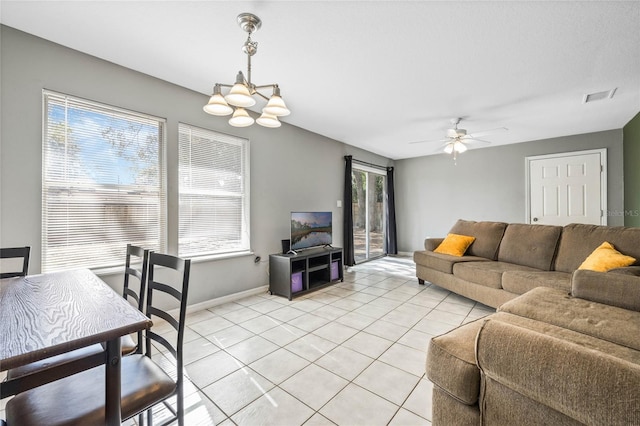 living room featuring light tile patterned floors and ceiling fan with notable chandelier