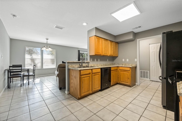 kitchen featuring dishwasher, stainless steel fridge, light stone countertops, light tile patterned floors, and a notable chandelier