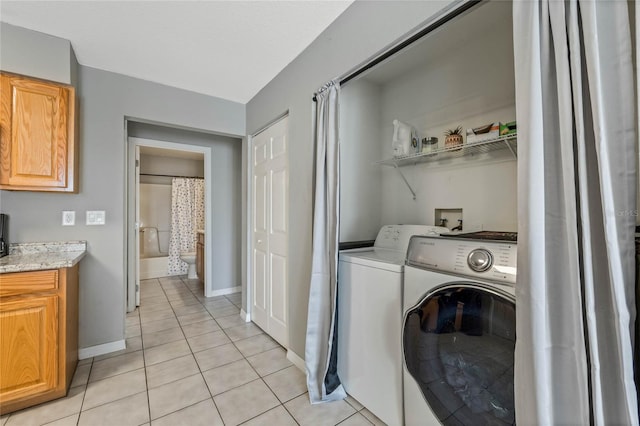 laundry area featuring washer and dryer and light tile patterned floors