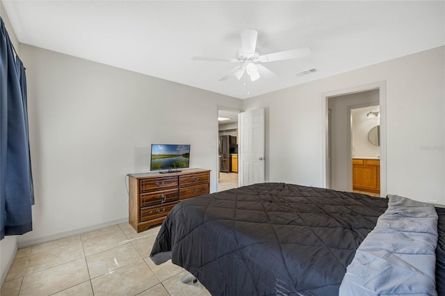 tiled bedroom featuring stainless steel refrigerator, ceiling fan, and ensuite bath