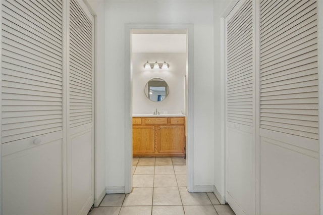 hallway with sink and light tile patterned flooring