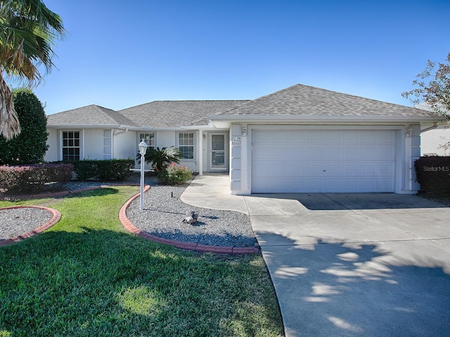 ranch-style home featuring a garage and a front lawn