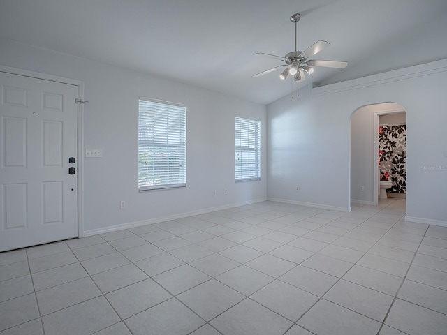 tiled empty room with ceiling fan and lofted ceiling