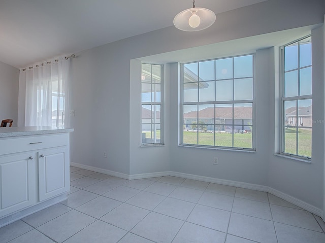 unfurnished dining area featuring light tile patterned floors