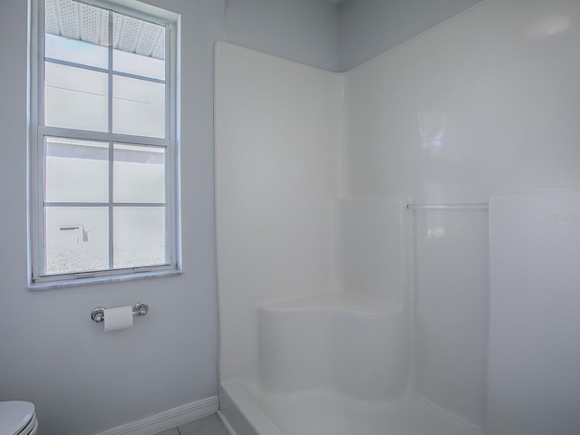 bathroom with toilet and a shower