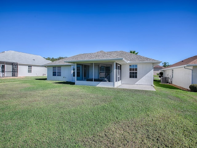 rear view of house featuring a yard, central AC unit, a patio area, and a sunroom