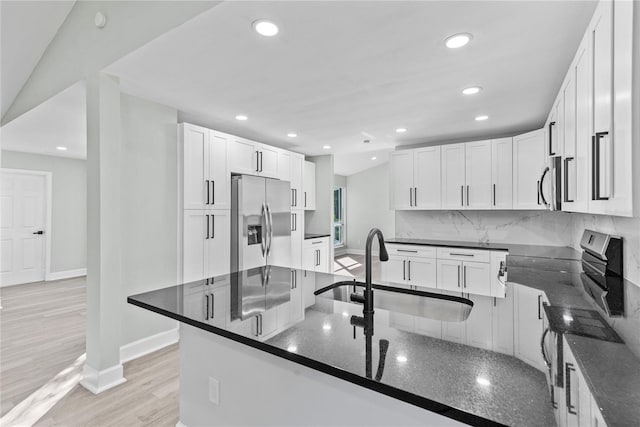 kitchen featuring sink, light wood-type flooring, white cabinetry, kitchen peninsula, and stainless steel appliances