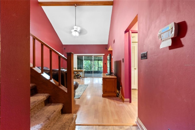 foyer featuring beam ceiling, light hardwood / wood-style flooring, and high vaulted ceiling