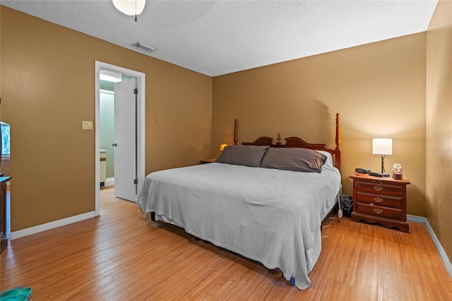 bedroom featuring a textured ceiling, light wood-type flooring, and ceiling fan