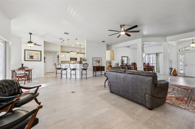 living room featuring ceiling fan, ornate columns, and light hardwood / wood-style flooring