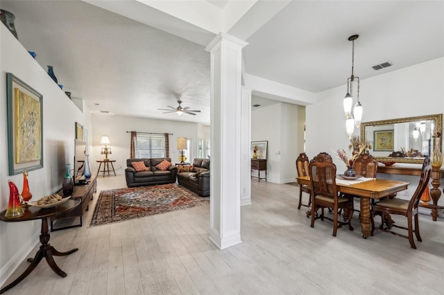 dining space featuring light wood-type flooring, ornate columns, and ceiling fan