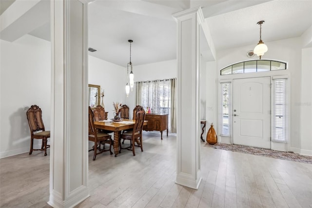 foyer entrance with ornate columns and light hardwood / wood-style flooring