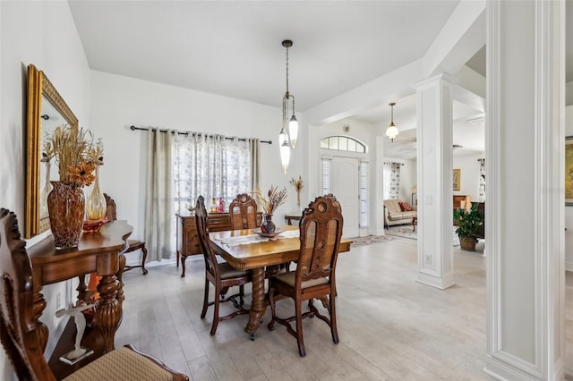 dining area featuring decorative columns and light hardwood / wood-style flooring