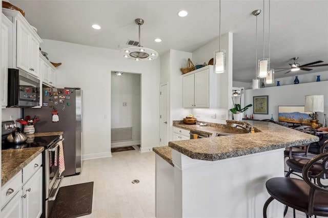 kitchen featuring white cabinetry, kitchen peninsula, stainless steel appliances, and hanging light fixtures