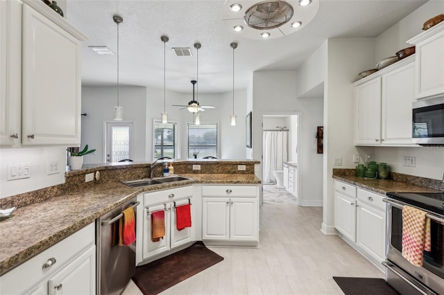 kitchen with decorative light fixtures, white cabinetry, kitchen peninsula, and appliances with stainless steel finishes