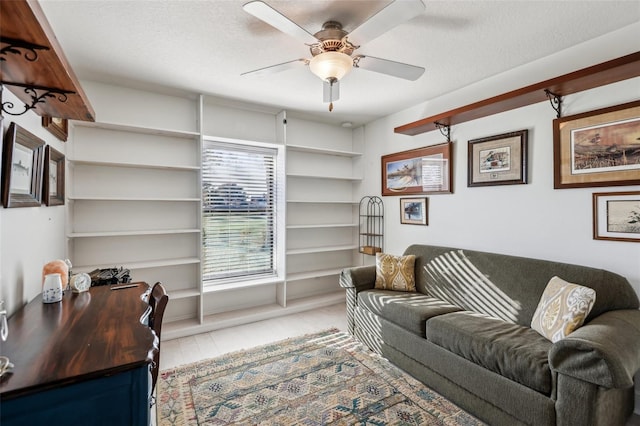 living room with a textured ceiling and ceiling fan